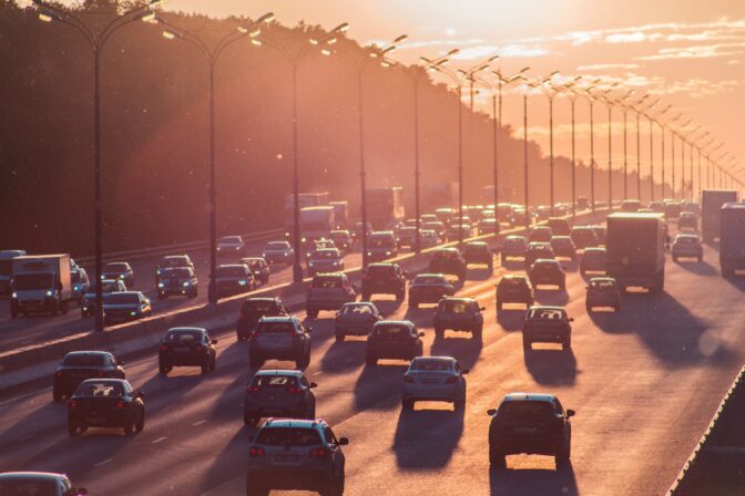 Cars driving on busy road during rush hour.